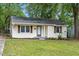 Cozy one-story house boasts well-manicured lawn, tidy landscaping, and neutral-toned exterior at 2453 Derby Dr, Raleigh, NC 27610