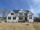 Stunning two-story home featuring white brick and siding, black shutters, and a welcoming front porch at 289 Streamside Dr, Angier, NC 27501