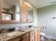 Bathroom with double vanity, granite countertop, wood cabinets, framed mirrors and tile floor at 30 Imperial Dr, Clayton, NC 27527
