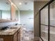 Bathroom with double sink vanity, granite countertop, tiled floors, and frameless glass shower at 30 Imperial Dr, Clayton, NC 27527