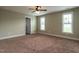 Spacious bedroom featuring neutral carpeting, large windows, and ample closet space at 30 Imperial Dr, Clayton, NC 27527
