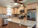 Well-lit kitchen features stainless steel appliances, granite countertops, and wooden cabinets at 30 Imperial Dr, Clayton, NC 27527