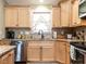 Well-lit kitchen area features wood cabinetry, a stainless steel dishwasher, and tiled backsplash at 30 Imperial Dr, Clayton, NC 27527