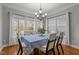 Bright dining room with large windows, hardwood floors, chandelier, and seating for six at 3003 Weston Green Loop, Cary, NC 27513
