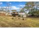 Backyard of home featuring fire pit, landscaping, and mature trees at 305 November St, Garner, NC 27529