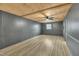 Finished basement featuring wood panel ceiling, hardwood floors, window, and gray walls at 305 November St, Garner, NC 27529