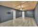 Basement features wood panel ceiling, wood floors, gray walls, and a ceiling fan at 305 November St, Garner, NC 27529