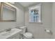 Bathroom with pedestal sink, toilet, towel holder, and framed mirror at 305 November St, Garner, NC 27529
