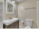 Bathroom with a dark wood vanity, large white sink, a toilet and medicine cabinet at 305 November St, Garner, NC 27529