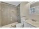 Modern bathroom featuring tiled shower with rainfall showerhead, toilet, and vanity with sink at 305 November St, Garner, NC 27529