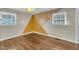 Bright bedroom with hardwood floors, ceiling fan, and unique geometric accent wall at 305 November St, Garner, NC 27529