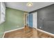 Bedroom with hardwood floors, multiple windows, and a blue painted door at 305 November St, Garner, NC 27529