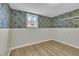 Bedroom with unique wallpaper, wood floor, a white framed window and modern shelving at 305 November St, Garner, NC 27529