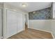 Bedroom with classic wood flooring, a full closet, stylish wallpaper and white trim at 305 November St, Garner, NC 27529