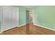 Bedroom featuring green walls, hardwood floors, an open doorway, and a large closet at 305 November St, Garner, NC 27529