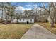 Charming white home with a neatly manicured lawn, complemented by lush greenery and a long driveway at 305 November St, Garner, NC 27529