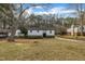Charming white home with a neatly manicured lawn, complemented by lush greenery and a long driveway at 305 November St, Garner, NC 27529