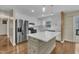 Bright kitchen boasts white cabinetry, stainless appliances, and a kitchen island with a countertop at 305 November St, Garner, NC 27529