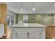 Kitchen island with white countertops, white cabinets and stainless steel handles overlooking the dining room at 305 November St, Garner, NC 27529