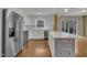 Open kitchen with stainless appliances and a quartz countertop island that overlooks the living room at 305 November St, Garner, NC 27529