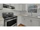 Bright kitchen features white subway tile backsplash, a window overlooking the yard and hardwood floors at 305 November St, Garner, NC 27529