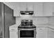 Kitchen features stainless appliances, white subway tile backsplash and white cabinetry at 305 November St, Garner, NC 27529