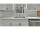 Bright kitchen features white countertops, white subway tile backsplash and a window overlooking the yard at 305 November St, Garner, NC 27529
