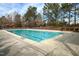 Outdoor pool surrounded by concrete, metal fence and green trees on a sunny day at 309 Mainline Sta, Morrisville, NC 27560