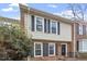 Inviting townhouse featuring a classic brick facade complemented by black shutters on sunlit windows at 318 Mccauley St # 2, Chapel Hill, NC 27516