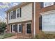 Townhouse exterior showcases brick and siding, accented by black shutters and tidy landscaping at 318 Mccauley St # 2, Chapel Hill, NC 27516