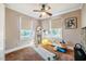 Functional bedroom space with neutral colors, ceiling fan, and natural light from large windows at 319 W Margaret Ln, Hillsborough, NC 27278