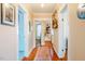 Hallway with hardwood floors connecting different rooms, showcasing open doorways and natural light at 319 W Margaret Ln, Hillsborough, NC 27278