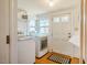 Bright laundry room with washer, dryer, and a door to the outside at 319 W Margaret Ln, Hillsborough, NC 27278