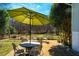 Covered backyard patio features a table, chairs, umbrella, and view at 319 W Margaret Ln, Hillsborough, NC 27278