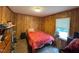This bedroom features a single bed, wood paneling, and a window for natural light at 322 Blackstone Rd, Sanford, NC 27330