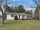 Charming home with a metal roof, inviting porch, and surrounded by mature trees at 322 Blackstone Rd, Sanford, NC 27330