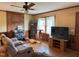 Cozy living room featuring a brick fireplace, wood paneling and comfortable seating at 322 Blackstone Rd, Sanford, NC 27330