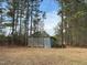 View of a metal outbuilding with a lawn mower parked alongside the structure at 322 Blackstone Rd, Sanford, NC 27330