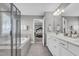 Elegant primary bathroom with double vanities, a glass-enclosed shower and tub, and an open bedroom view at 3460 Willow Green Dr, Apex, NC 27502