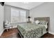 Comfortable bedroom featuring a decorative bedspread, hardwood floors, and lots of natural light at 3460 Willow Green Dr, Apex, NC 27502