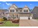 Charming two-story home featuring a stone facade, inviting front porch, and well-manicured lawn at 3460 Willow Green Dr, Apex, NC 27502