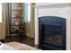 Close-up of the fireplace with its elegant white mantel and decorative shelving unit nearby at 3460 Willow Green Dr, Apex, NC 27502