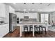 Modern kitchen featuring white cabinets, stainless steel appliances, and a large island with seating at 3460 Willow Green Dr, Apex, NC 27502