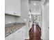 Bright kitchen with granite countertops, white cabinetry, and a view into the dining area at 3460 Willow Green Dr, Apex, NC 27502