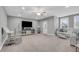 Spacious living room featuring a ceiling fan, television, bar, and comfortable white couch at 3460 Willow Green Dr, Apex, NC 27502