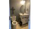 Bathroom featuring a white vanity with a modern sink, oval mirror, and a toilet, all in a gray-toned color scheme at 401 Lawton Dr, Haw River, NC 27258
