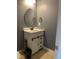 Bathroom with a white vanity, black fixtures, and an oval mirror at 401 Lawton Dr, Haw River, NC 27258