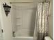 Bright bathroom featuring a shower and tub combination with white shelving at 401 Lawton Dr, Haw River, NC 27258