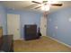Carpeted bedroom with blue walls and ceiling fan at 401 Lawton Dr, Haw River, NC 27258