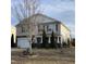 Charming two-story home features a stone facade, red shutters, a well-manicured lawn, and a two-car garage at 401 Lawton Dr, Haw River, NC 27258
